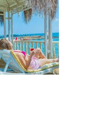 Turista relajándose en tumbona con vistas al mar desde la terraza del Hotel Master Plaza