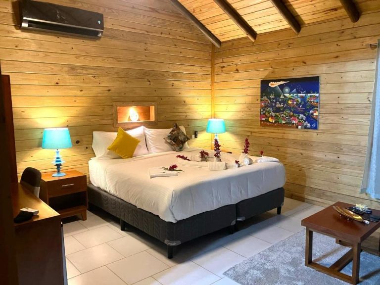 Habitación con paredes de madera y cama doble decorada con flores en Hotel Amigo Nicaragua