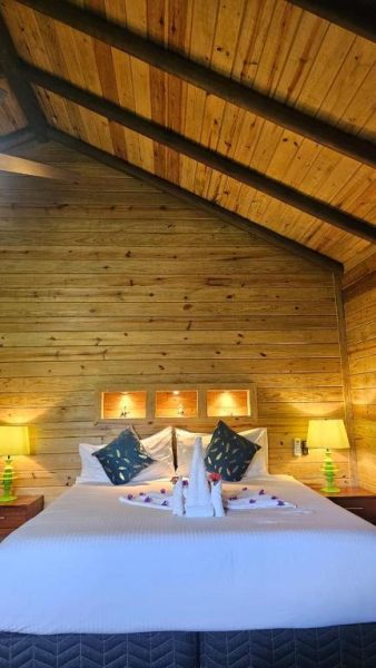 Habitación rústica con cama doble y techo de madera artesanal en Hotel Amigo Nicaragua