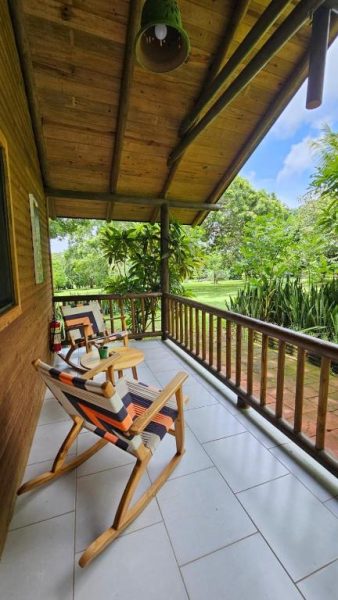 Terraza con sillas mecedoras y vistas al jardín tropical del Hotel Amigo Nicaragua