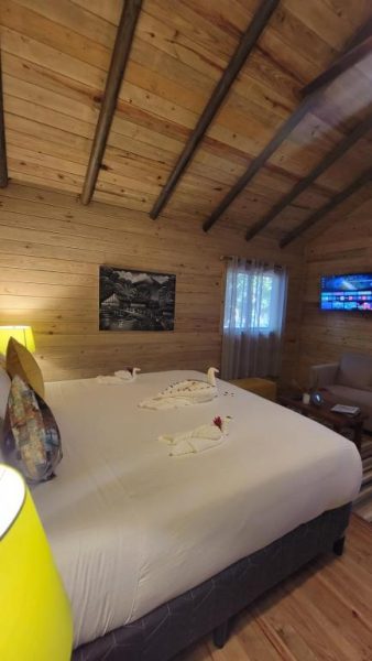 Habitación romántica con cama doble y decoración de cisnes en cabaña de madera del Hotel Amigo Nicaragua