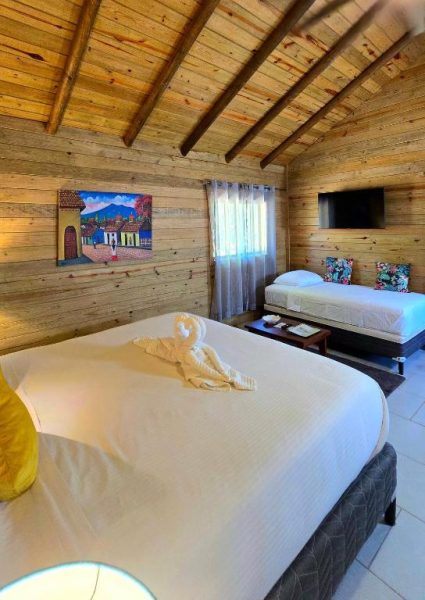 Habitación doble tipo cabaña de madera con dos camas y decoración artesanal en Hotel Amigo Nicaragua