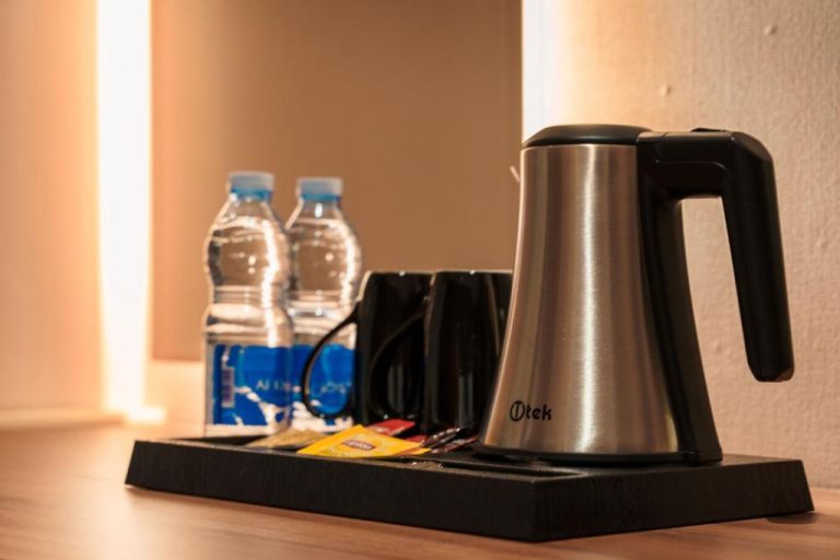 Tetera eléctrica Itek y botellas de agua en la habitación del Jarzez Inn Hotel Azaiba