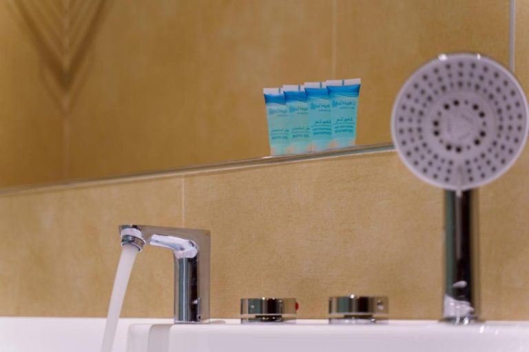 Baño con ducha, grifo y amenities de gel y champú en Jarzez Inn Hotel Azaiba