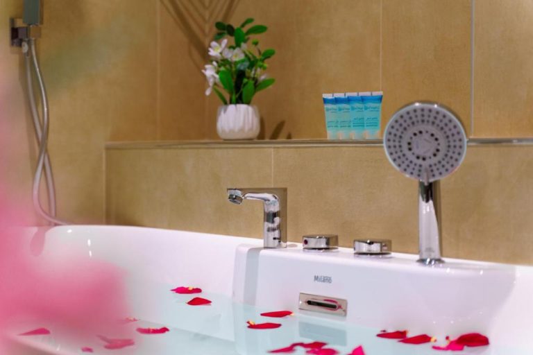 Bañera romántica con pétalos de rosa y ducha en el spa del Jarzez Inn Hotel Azaiba