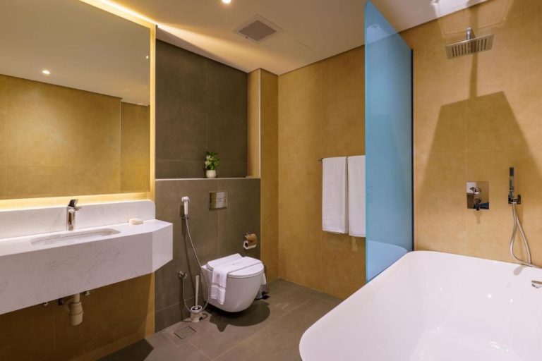 Baño de suite de lujo con bañera exenta, ducha de lluvia y lavabo de mármol en Jarzez Inn Hotel Azaiba