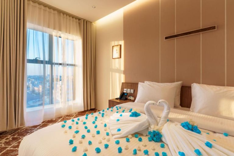Habitación romántica decorada con rosas azules y cisnes de toallas en Jarzez Inn Hotel Azaiba