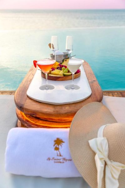 Cócteles tropicales y tabla de frutas junto a la piscina infinita con vista al mar en Le Saint Tropez