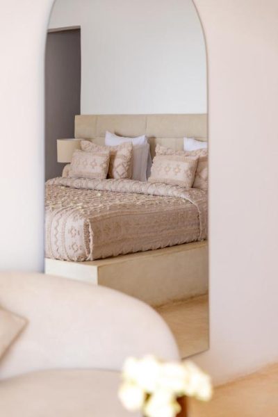 Habitación doble con decoración beige y espejo de arco en el hotel Le Saint Tropez