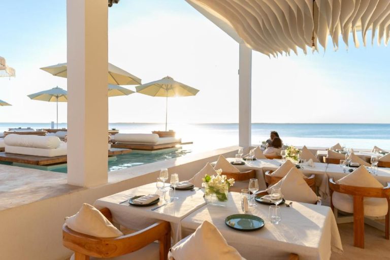 Restaurante terraza frente al mar con mesas elegantes y piscina infinita en Le Saint Tropez