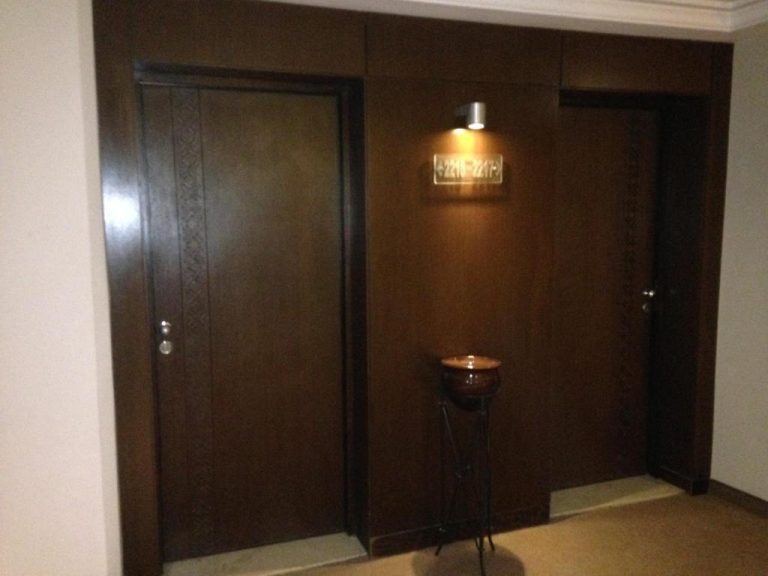 Pasillo con puertas de madera oscura de las habitaciones 2210 y 2211 del Hotel Continental