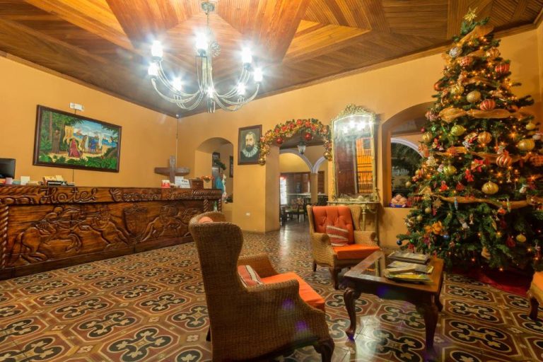 Recepción colonial del Hotel Córdoba decorada con árbol de Navidad y mostrador de madera tallada
