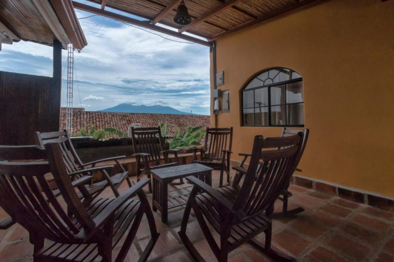 Terraza con sillas de madera y vistas a las montañas en Hotel Córdoba