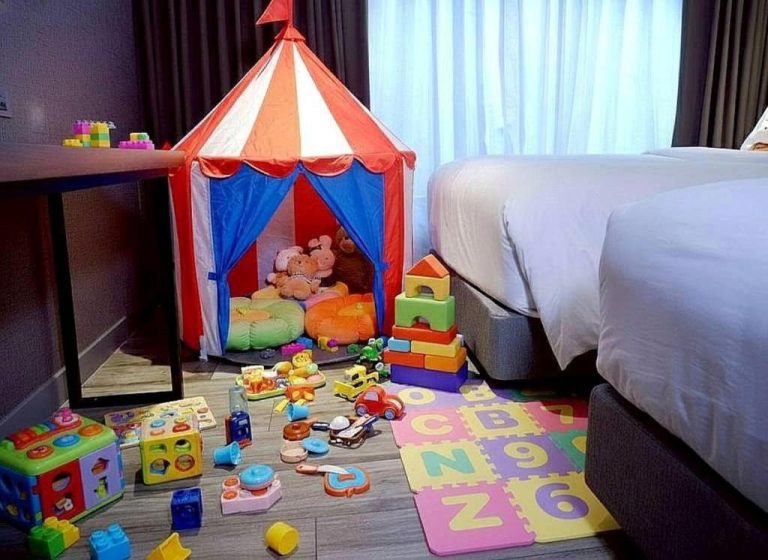 Habitación familiar del Ayathorn Bangkok con tienda de juegos, juguetes y alfombra educativa para niños