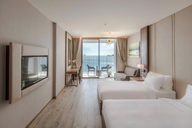 Habitación doble con dos camas y balcón con vistas al mar en Aqualune Residence Beachfront