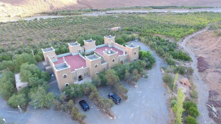 Vista aérea del Kasbah Hotel Camping Jurassique con arquitectura tradicional marroquí rodeada de vegetación desértica