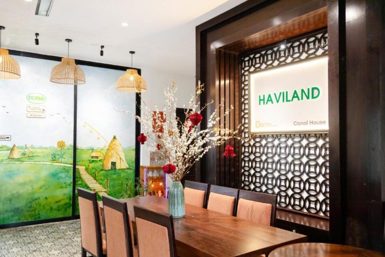 Comedor y recepción con mural campestre del Hoi An Canal House Riverside By Haviland