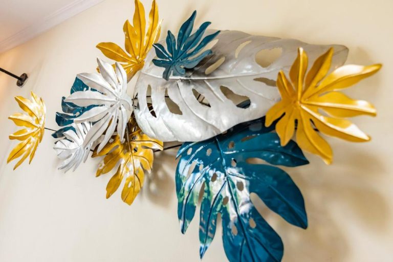 Decoración artística de hojas tropicales metálicas en colores dorado, azul y blanco en Svadarma Bali Villa