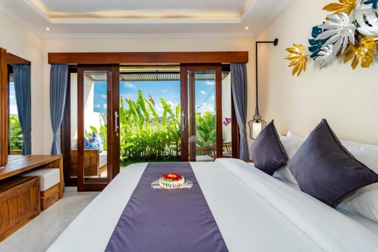 Habitación de lujo con cama doble y vistas a jardín tropical en Svadarma Bali Villa