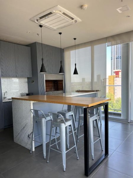 Cocina equipada con barra de madera y sillas altas en terraza del Solara Hotel Boutique
