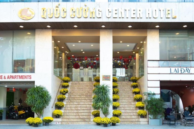 Fachada principal del Quoc Cuong Center Hotel en Danang con escalinata decorada con flores amarillas