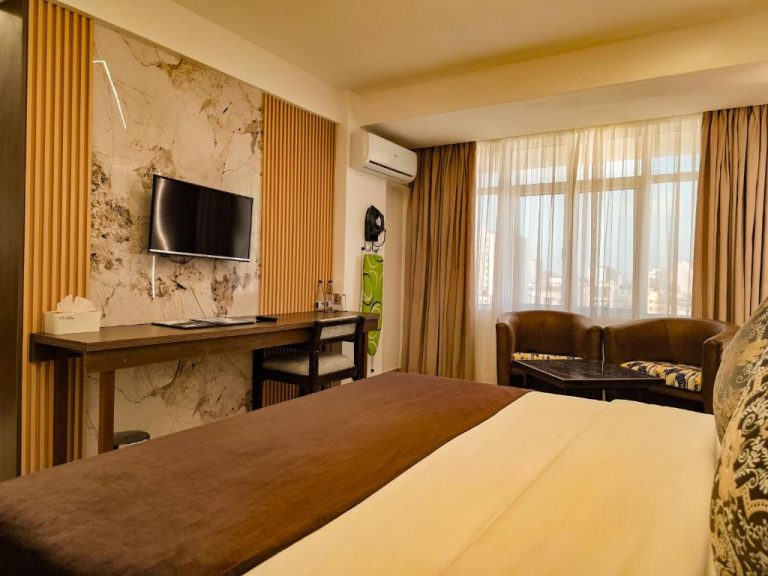 Habitación doble con cama, escritorio, televisión y sillones del Hotel Sapphire