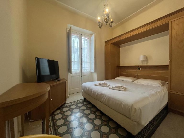 Habitación doble clásica con cama matrimonial y suelo hidráulico en Hotel Liberty