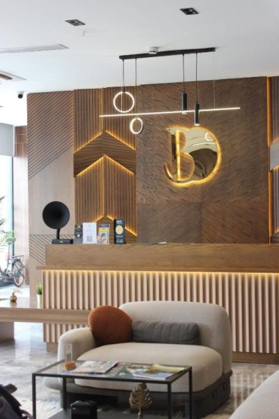 Recepción moderna con diseño en madera y logo iluminado del Bonnie City Hotel