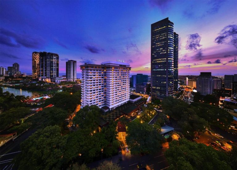 Vista panorámica nocturna del Hilton Colombo Hotel con skyline iluminado al atardecer en Sri Lanka