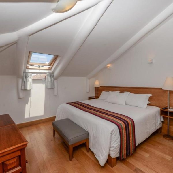 Habitación doble con techo abuhardillado y suelo de madera en Hotel Plaza de Armas Cusco
