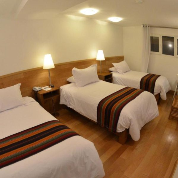 Habitación triple con tres camas y decoración andina en Hotel Plaza de Armas Cusco