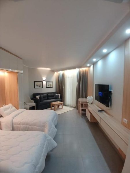 Suite amplia con dos camas y sala de estar en el Hotel y Resort Skandic, con TV y diseño moderno