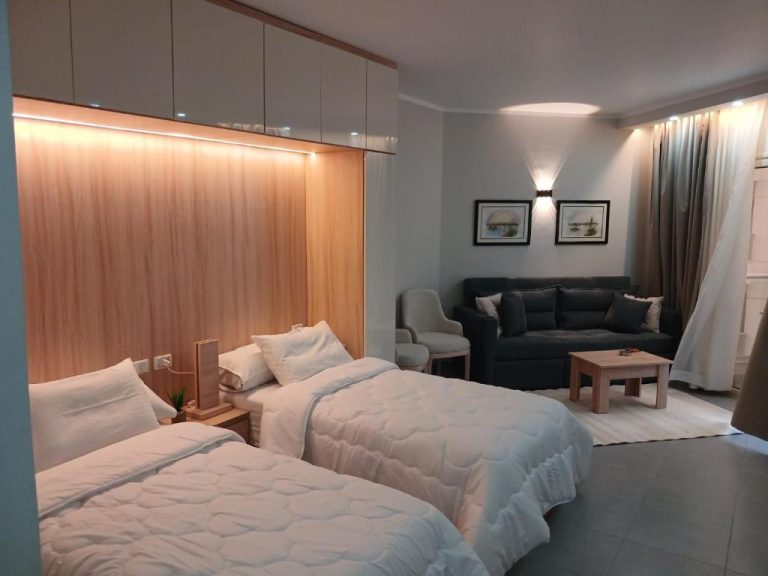Habitación doble con dos camas y zona de salón en el Hotel y Resort Skandic, decoración moderna