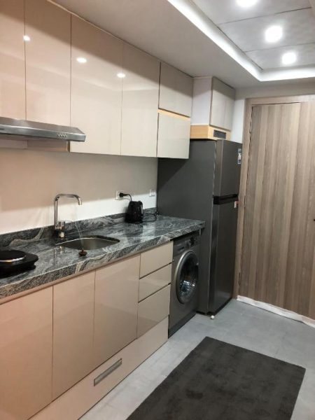 Cocina moderna equipada con lavadora y nevera en el chalet del Hotel y Resort Skandic