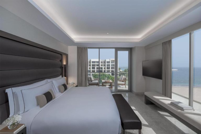 Habitación de lujo con cama king size, balcón y vistas al mar en Kempinski Hotel Muscat
