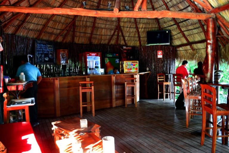 Bar tropical con techo de palma y ambiente caribeño en el Laguna Beach Club