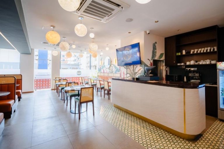 Restaurante interior del MK Colombo con barra de recepción, mesas y lámparas esféricas decorativas