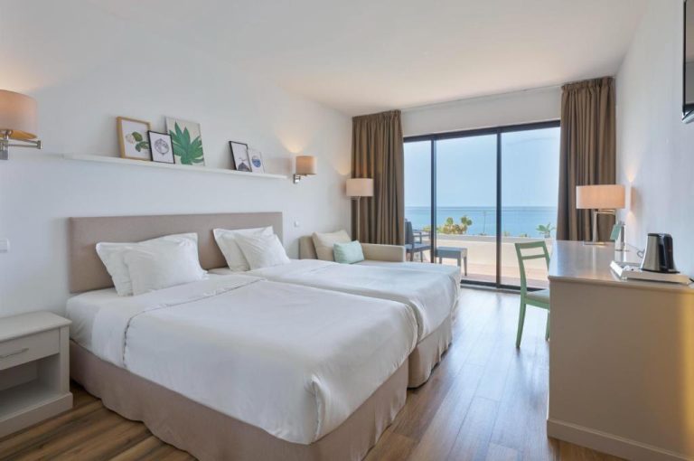 Habitación doble con camas individuales y vistas al mar en Caloura Hotel Resort