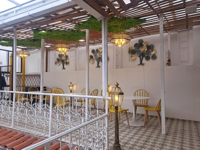 Terraza restaurante con sillas amarillas y lámparas colgantes del Rossa Mia Hotel Boutique