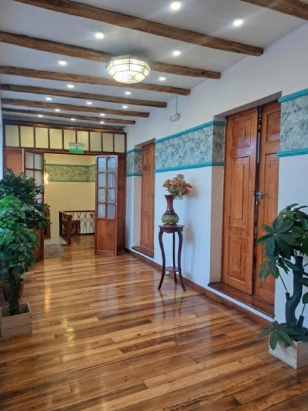 Corredor interior con suelo de madera y vigas decorativas del Rossa Mia Hotel Boutique