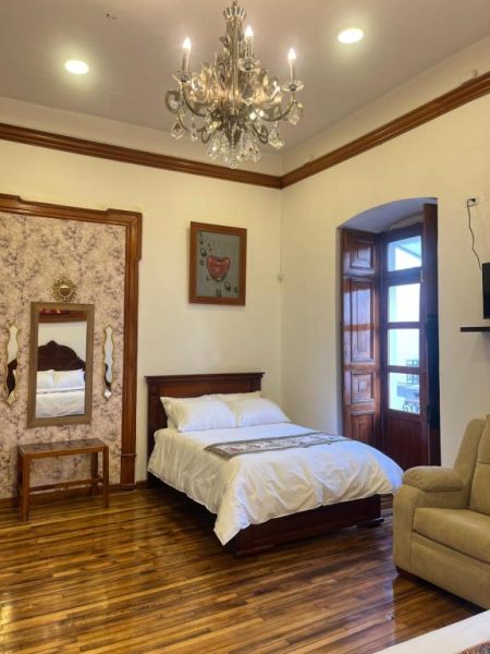 Habitación clásica doble con cama matrimonial y lámpara de araña en Rossa Mia Hotel Boutique