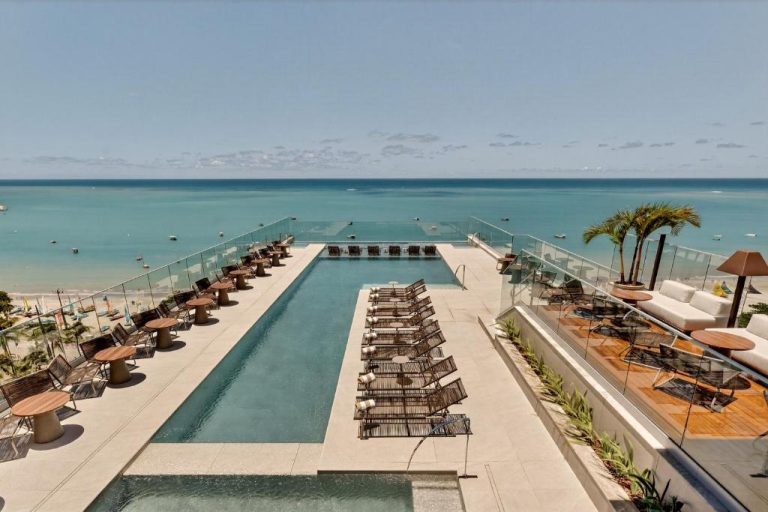 Piscina infinita con tumbonas y vistas al mar turquesa en el Venti Hotel by Brisa Hotéis