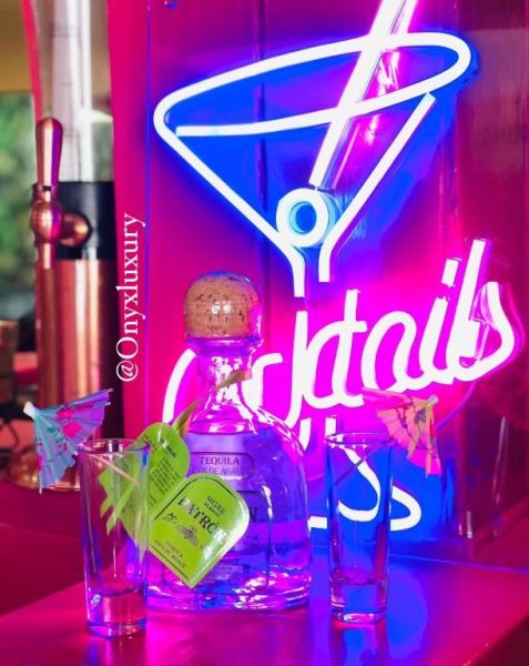 Barra de coctelería con tequila Patrón Silver y letreros de neón en Onyx Luxury RD