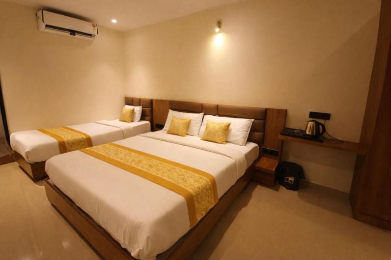 Habitación triple con dos camas dobles y decoración dorada en el Hotel Lancaster
