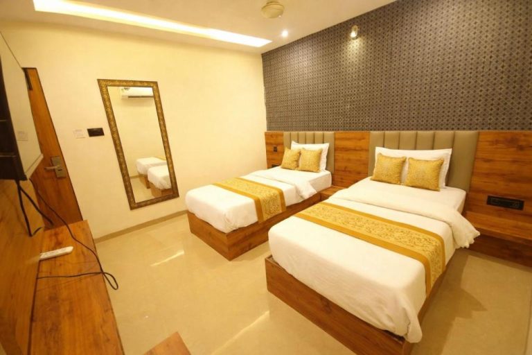 Habitación doble con dos camas individuales y decoración en dorado del Hotel Lancaster