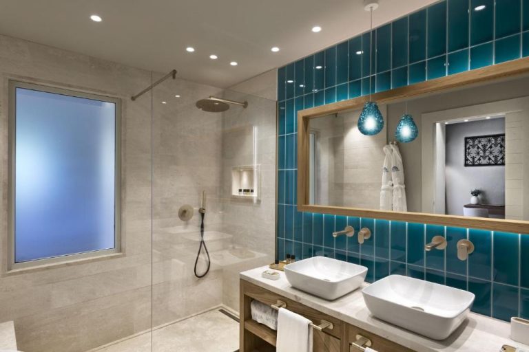 Baño moderno con doble lavabo y ducha del Hotel La Bisaccia, decorado con azulejos turquesa