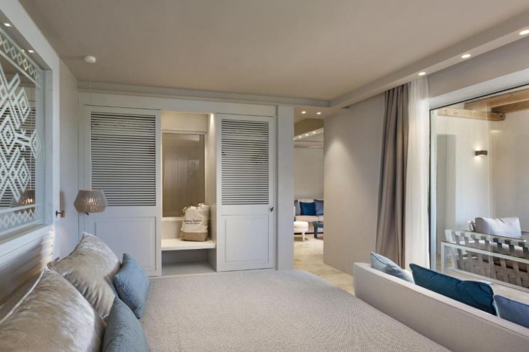 Suite elegante con sofás blancos, armarios empotrados y terraza exterior en Hotel La Bisaccia