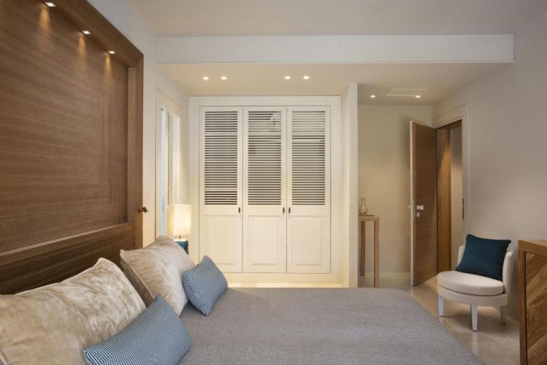 Habitación doble con cabecero de madera y armario empotrado blanco en Hotel La Bisaccia