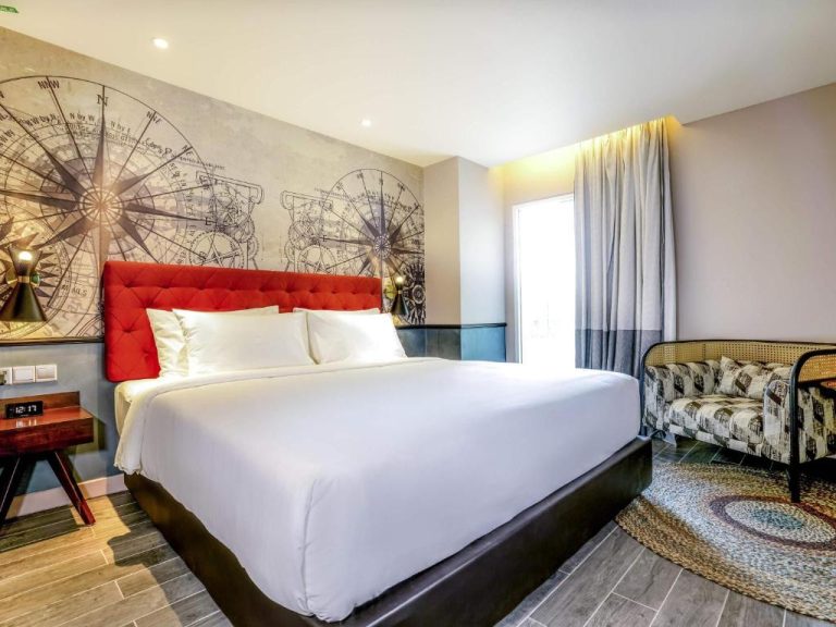 Habitación superior con cama king size y cabecero rojo en Mercure Langkawi Pantai Cenang