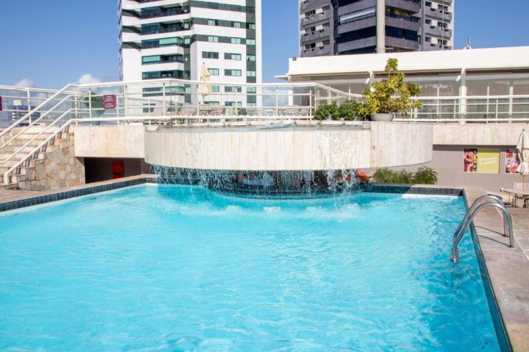 Piscina exterior con cascada decorativa del Hotel Atlante Plaza con vistas a los edificios de la ciudad